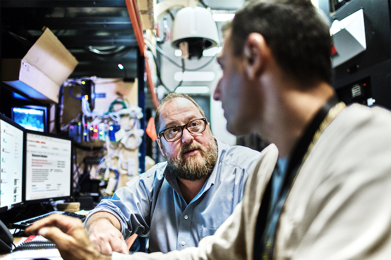 two men collaborating on computers in public safety