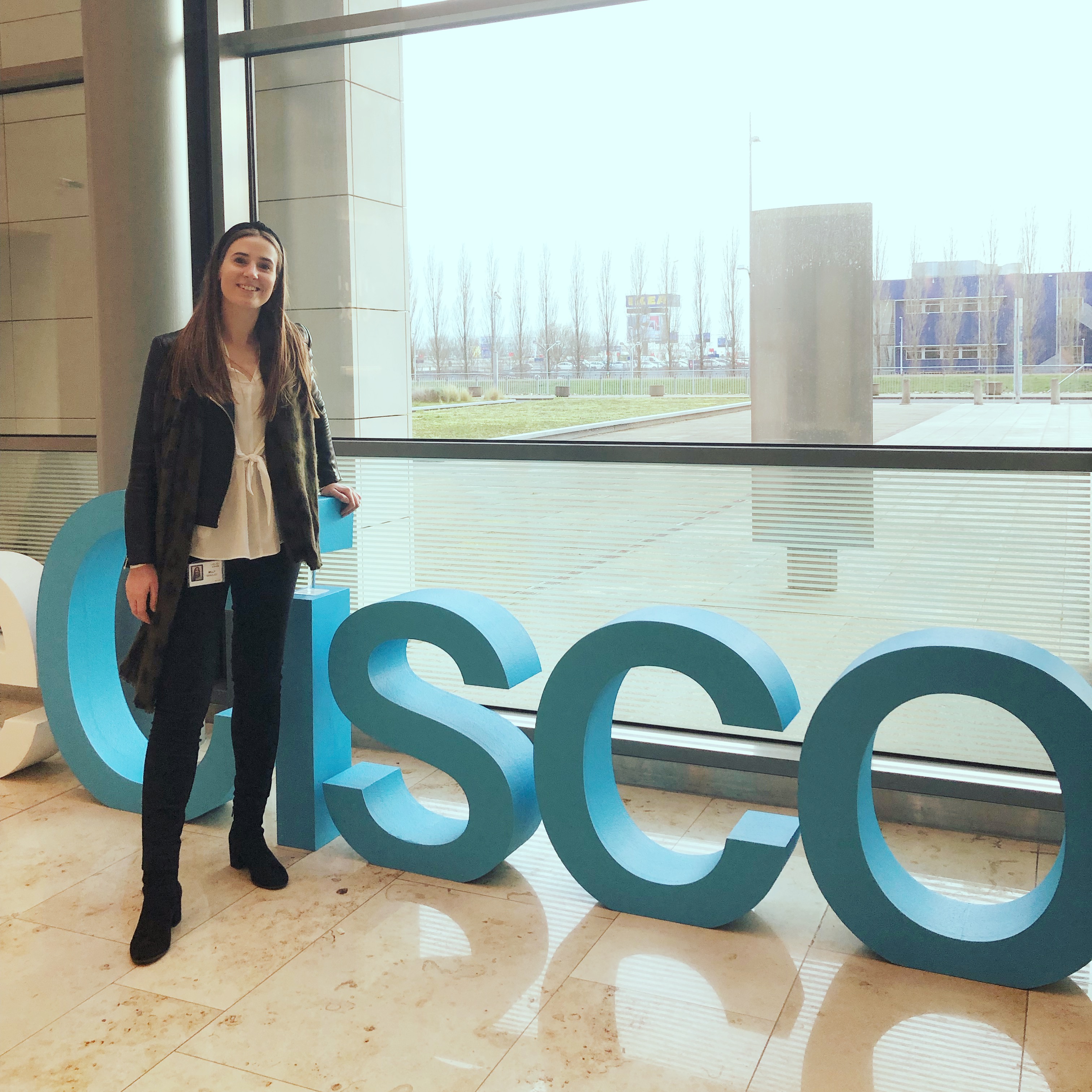 Milly stands in front of 3-D letters spelling out Cisco