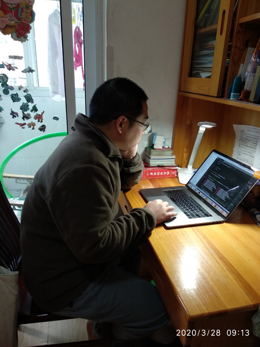 Guangcheng Zhoa sits at his desk working.