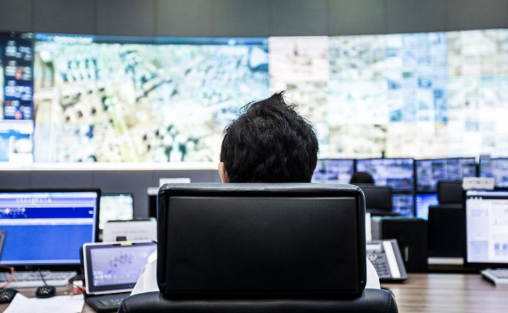 A person sitting in an office chair looking at screens