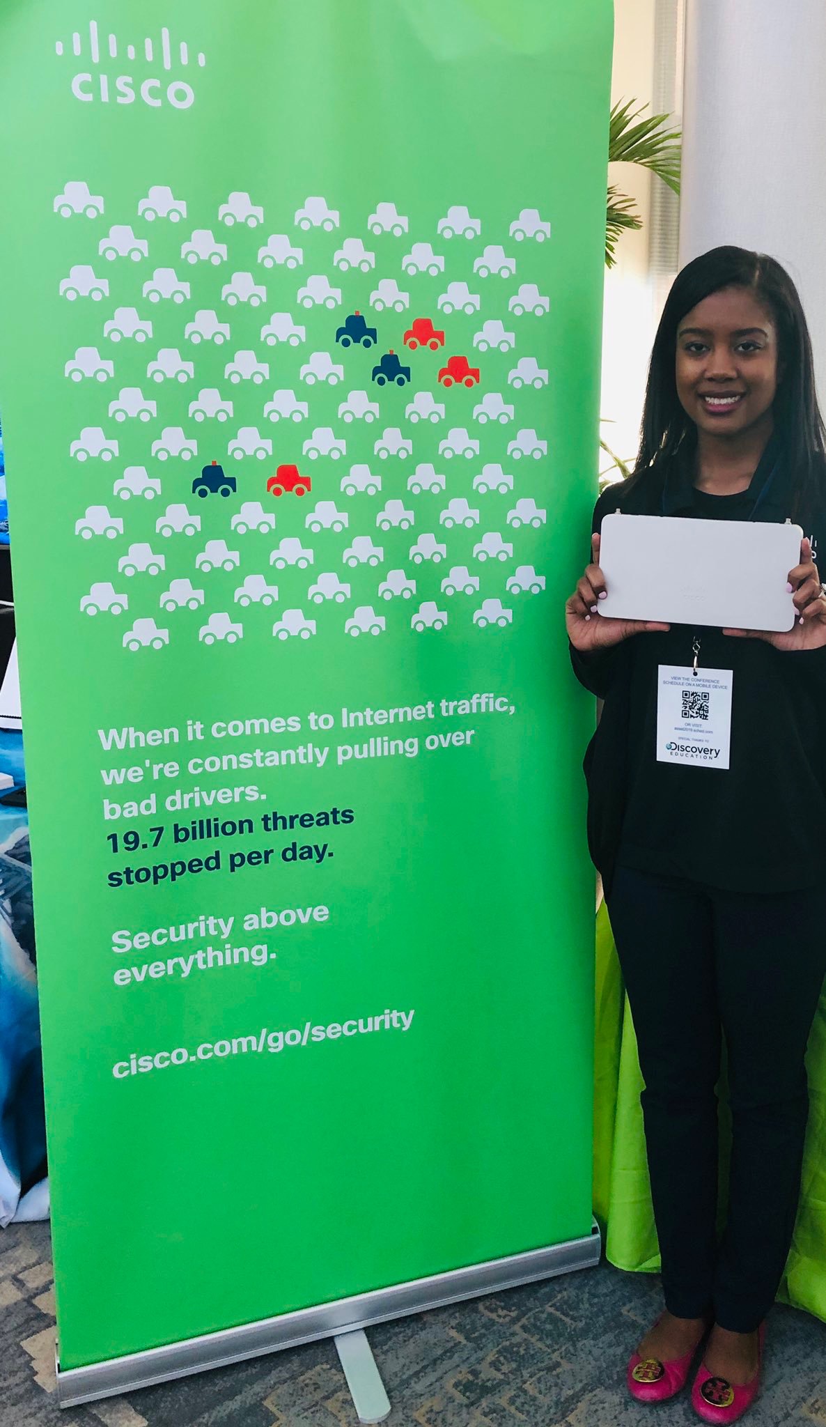 Bree stands in front of a bright green Cisco sign at Long Island Summit.