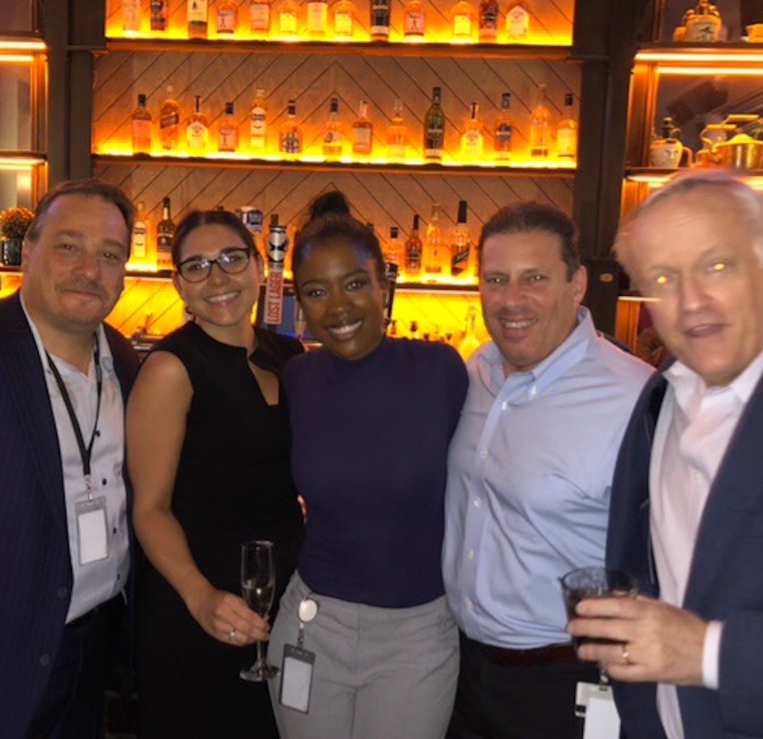 Bree stands in the middle of a few NYC co-workers