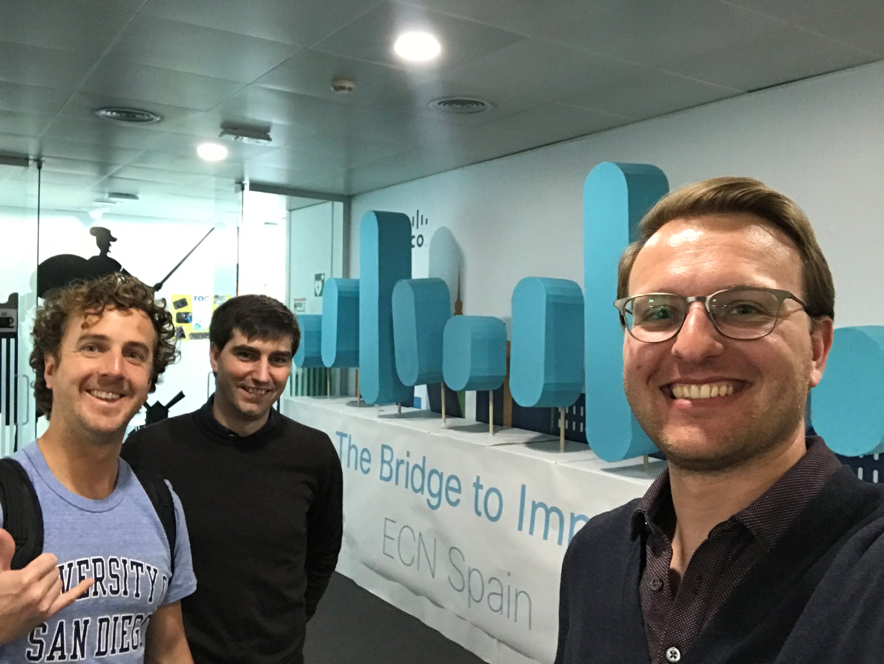 Daivd and his peers stand in front of a sculpture of the Cisco logo at Cisco Spain.