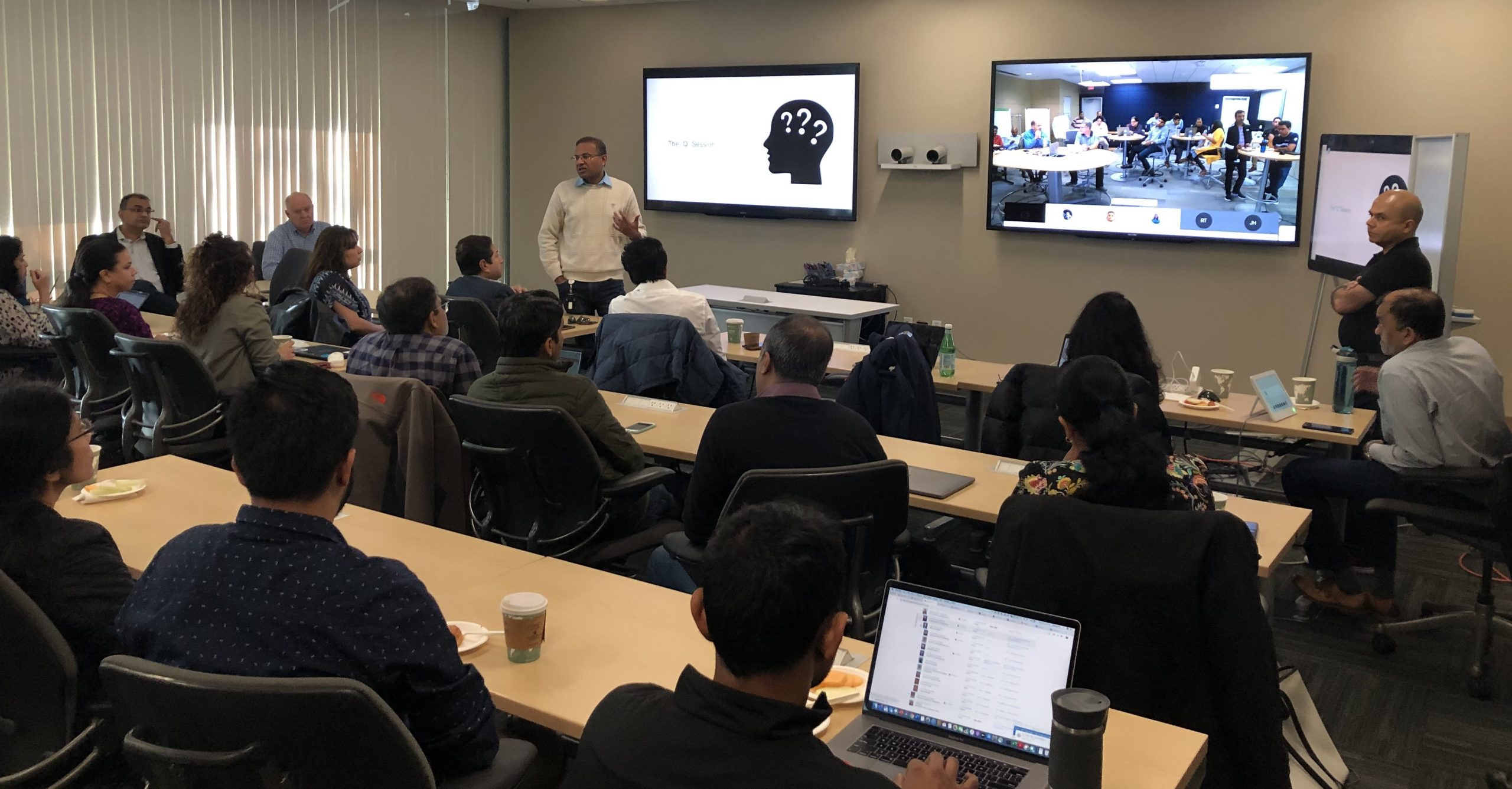 Jay Chow in a conference room for an all hands meeting with a group of his peers.
