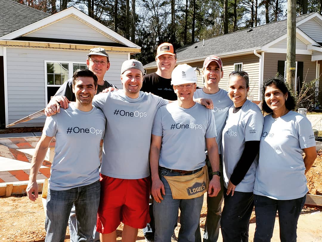 David and the #OneOps team standing together at a give back event building houses.