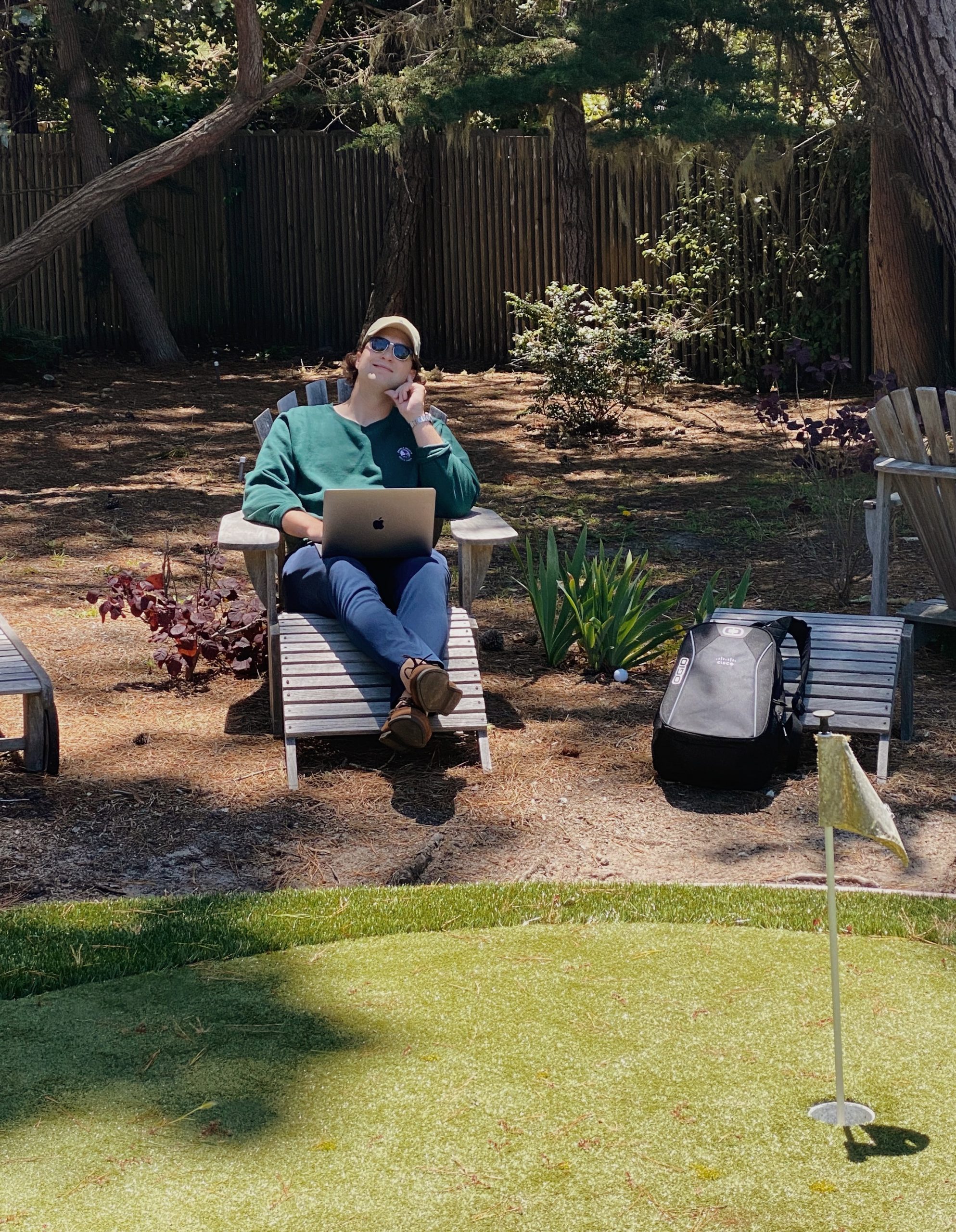 Matthew shares a bit of his personality by working in a chair outside next to a putting green.