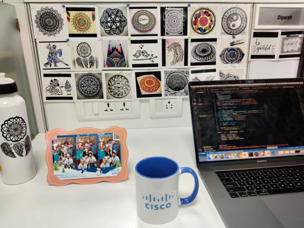 Diparati's desk showing off her Mandala and Zentangle art while writing code on her computer.