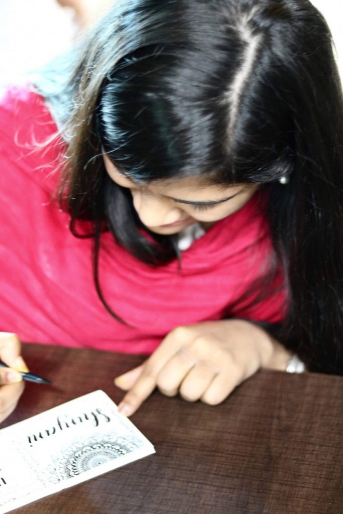 Diparati signs Women's Day cards at Cisco with her artwork.
