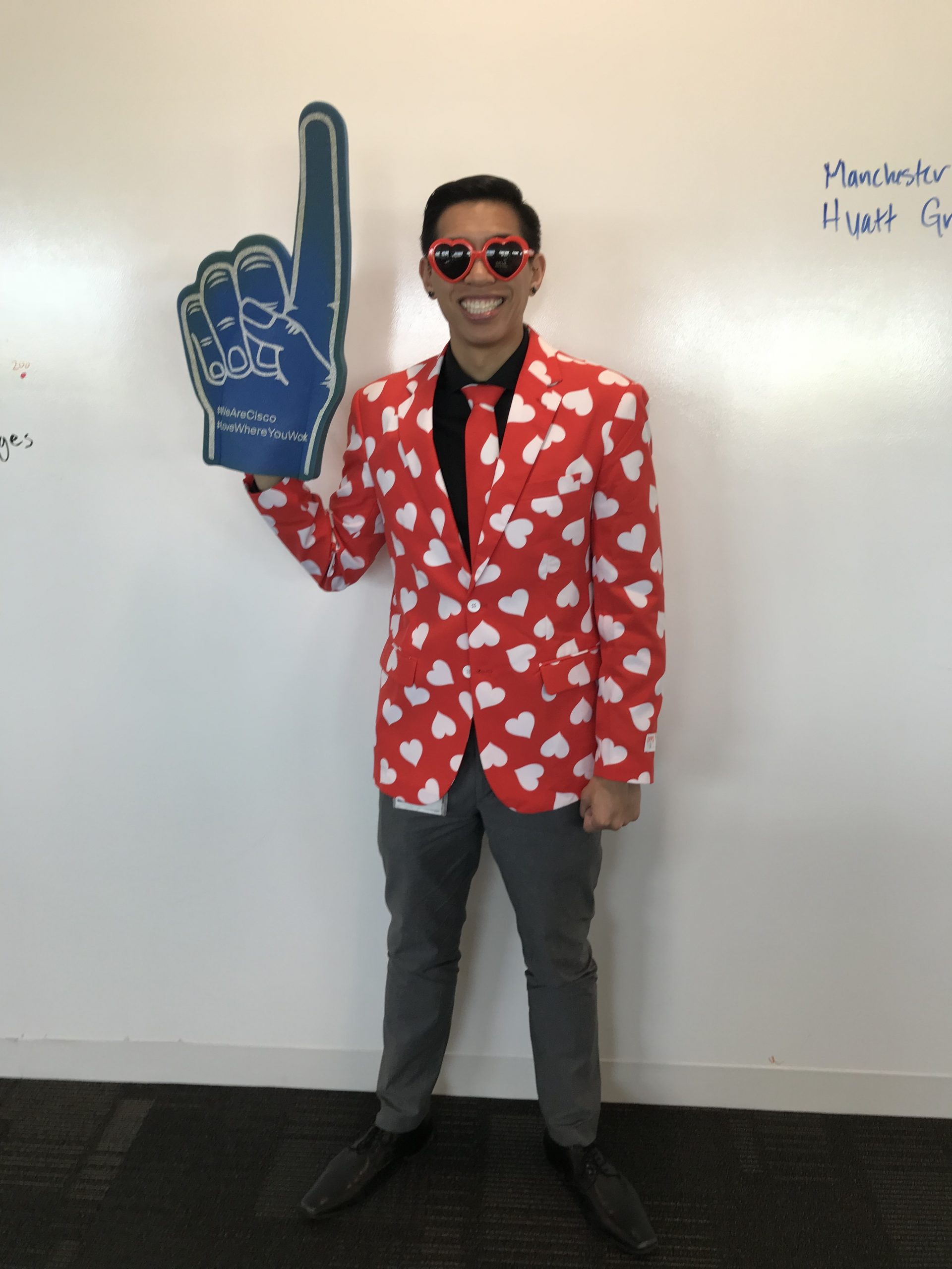 Justin wears a heart suit and a "#1 foam finger" to celebrate Cisco's #1 World's Best Workplace.