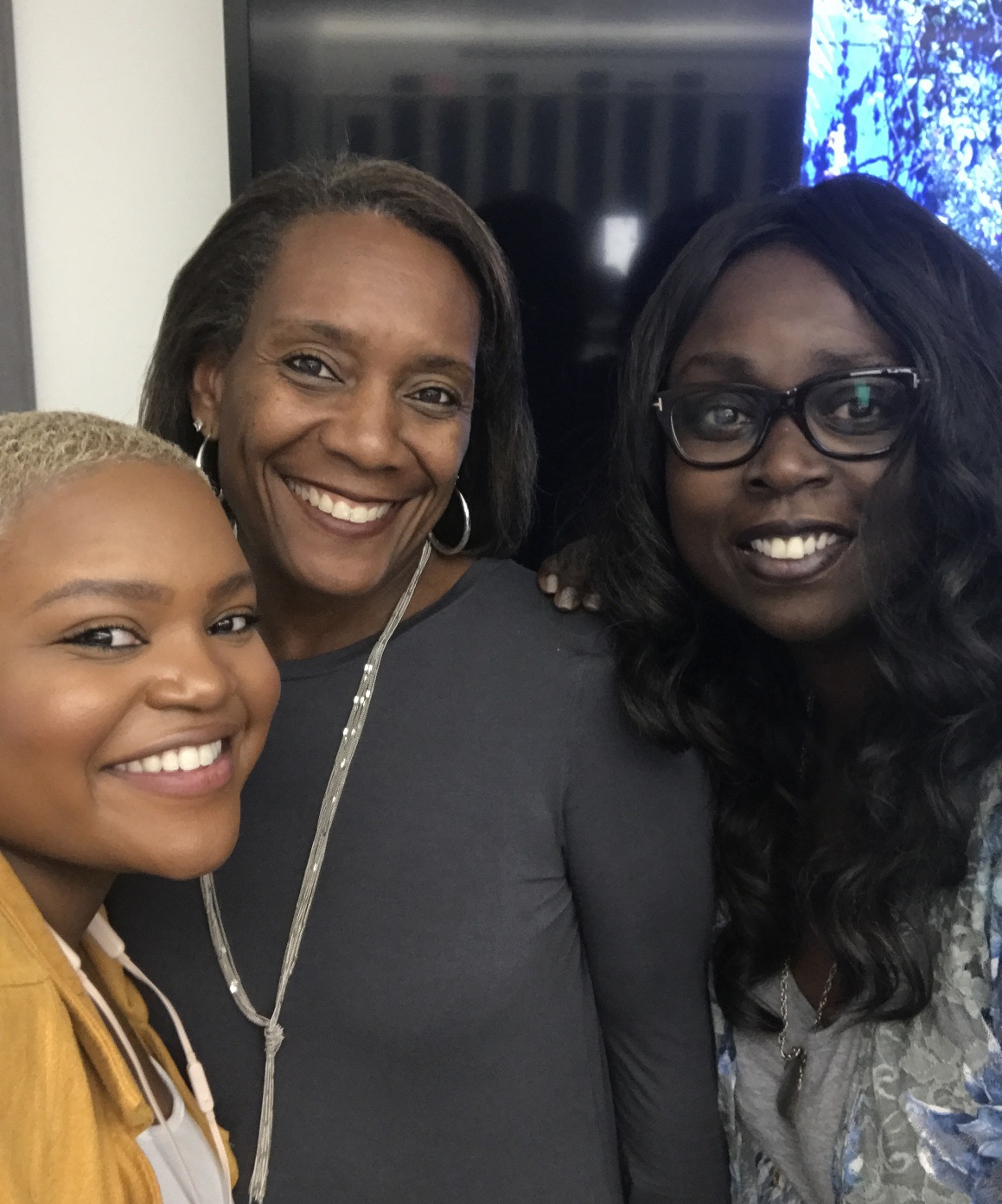 Milissa smiles with two of her peers