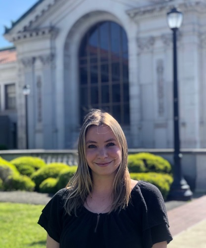 Juliette Ulaga stands outside in front of a building.