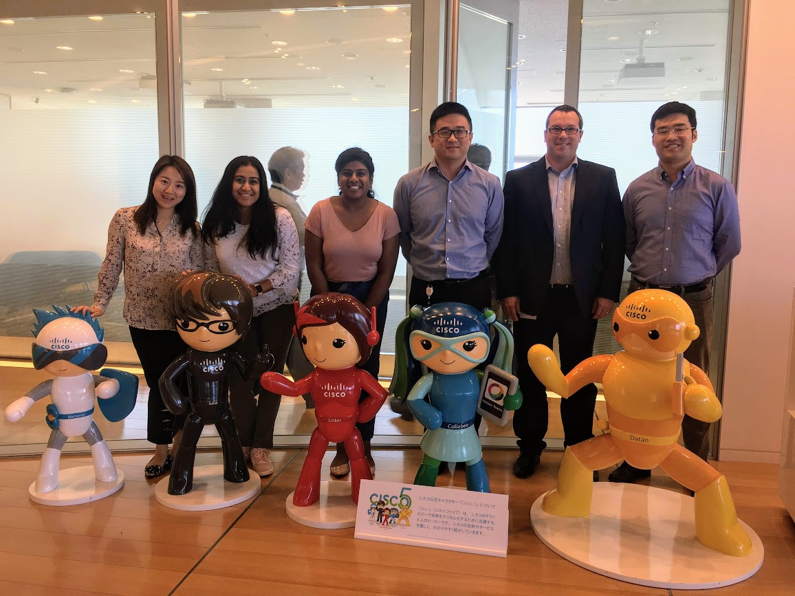 Prabha and her team stand with the "Cisco 5" in the Japan office.