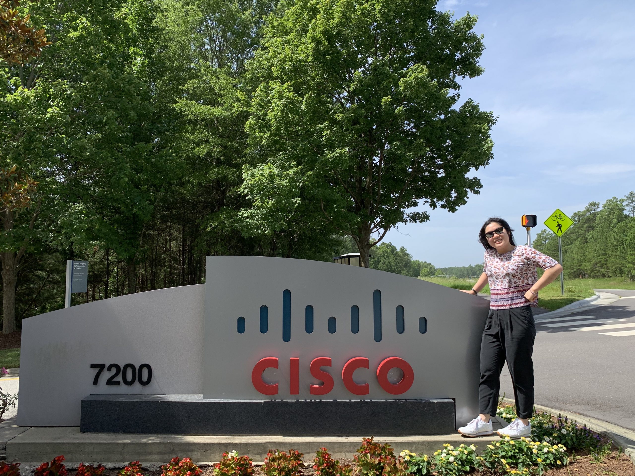 Rashona stands proudly next to a Cisco sign outside at our RTP campus.