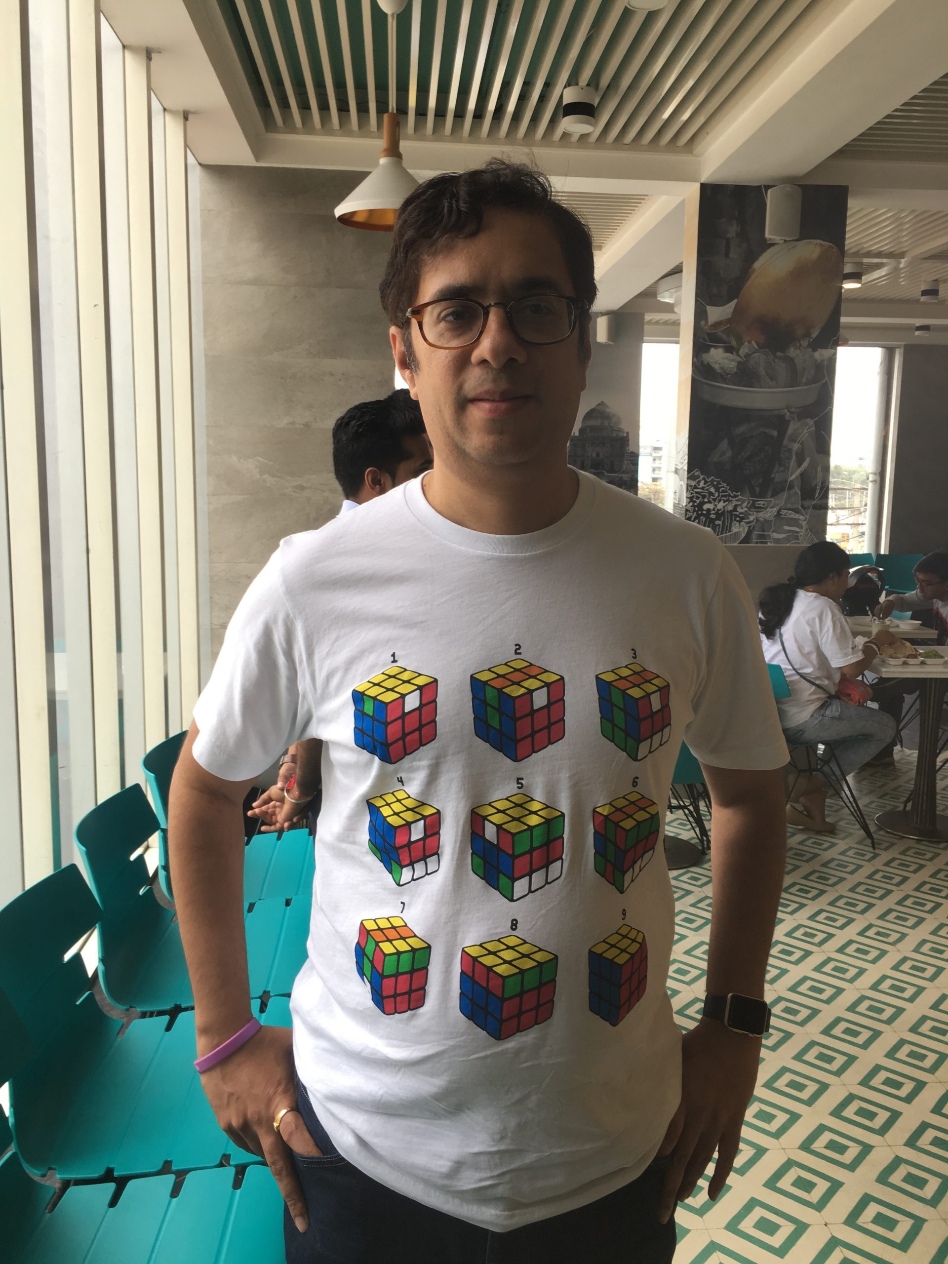 Vivasvan smiles for the camera while wearing a how to solve a rubix cube shirt.