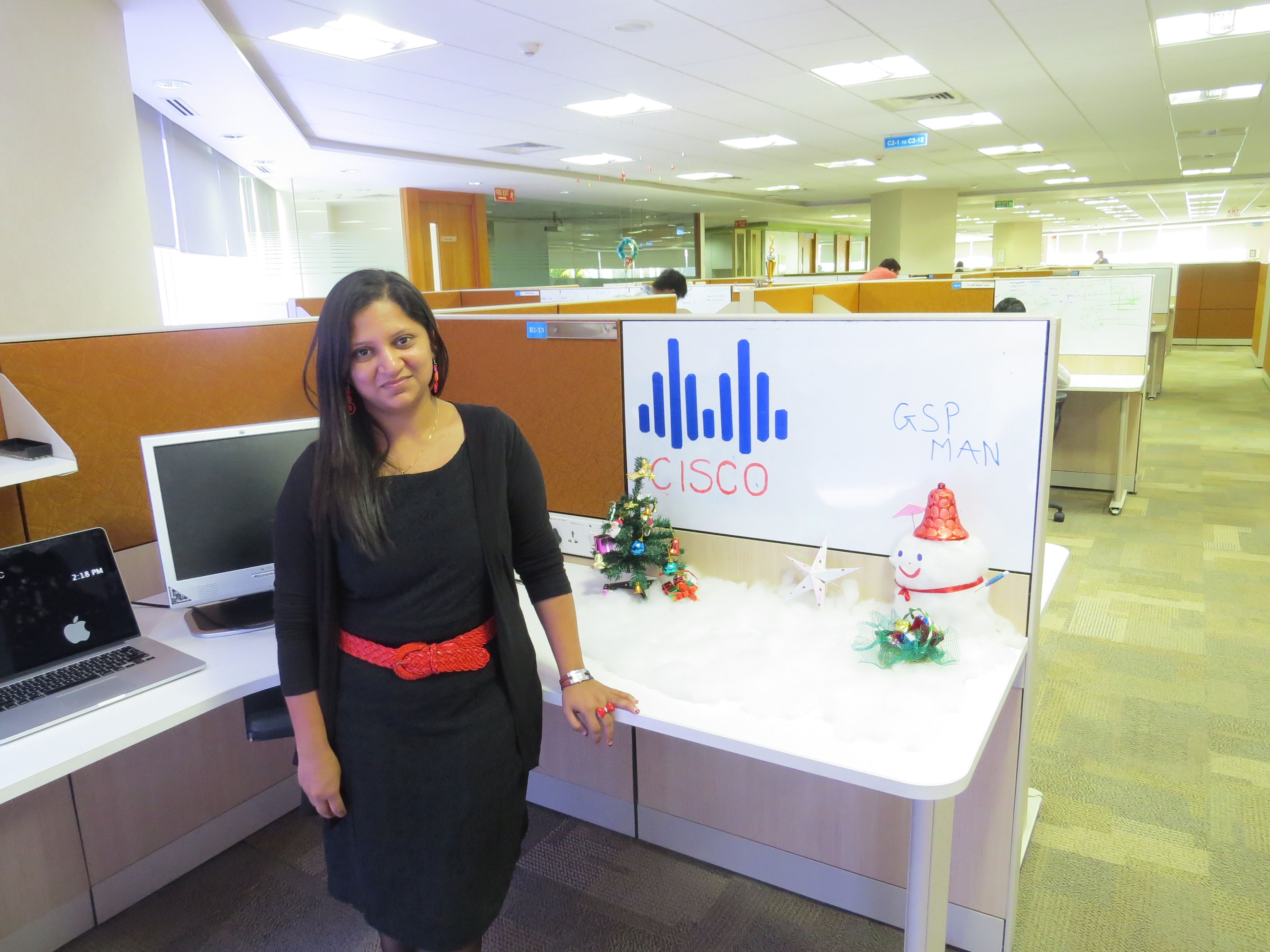 Bansari in front of desk and Cisco logo. 