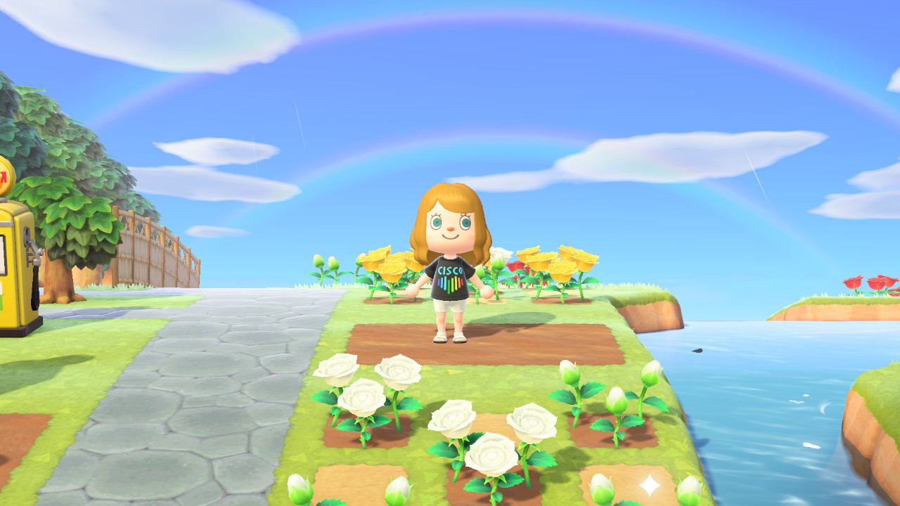 Carmen stands under a double rainbow in her Cisco Pride tshirt on her Animal Crossing island.