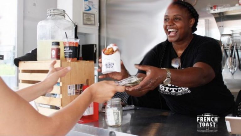 Charisse handing out french toast bites to a customer