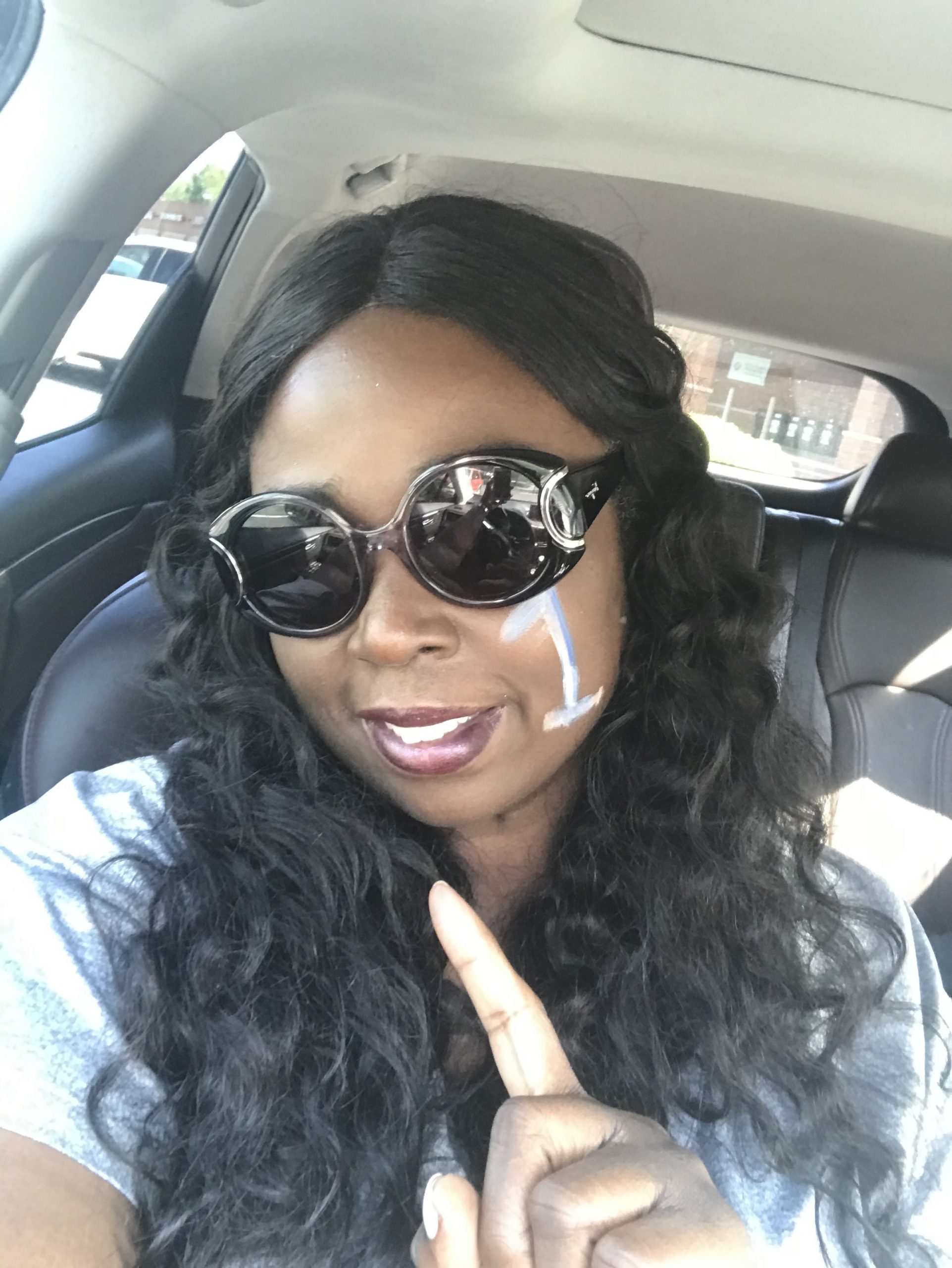 Melissa has #1 painted on her cheek and holds up her finger as #1.