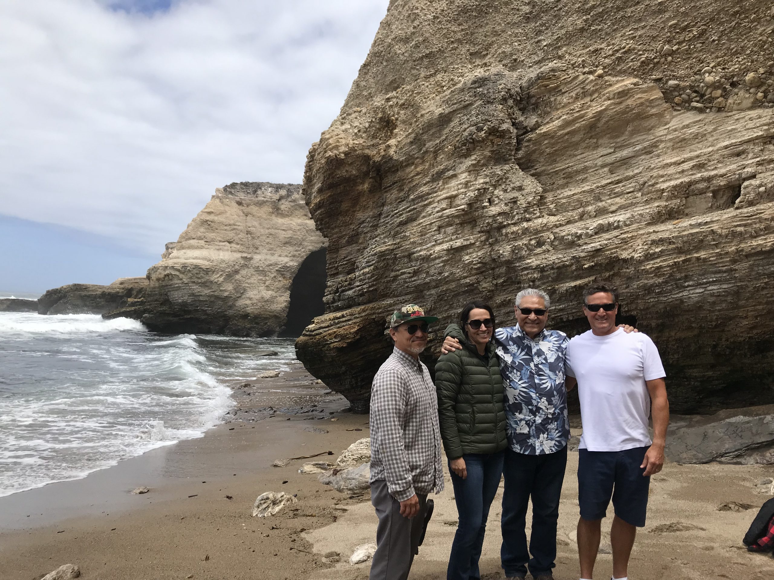 Ken, his dad, and siblings on a beach.