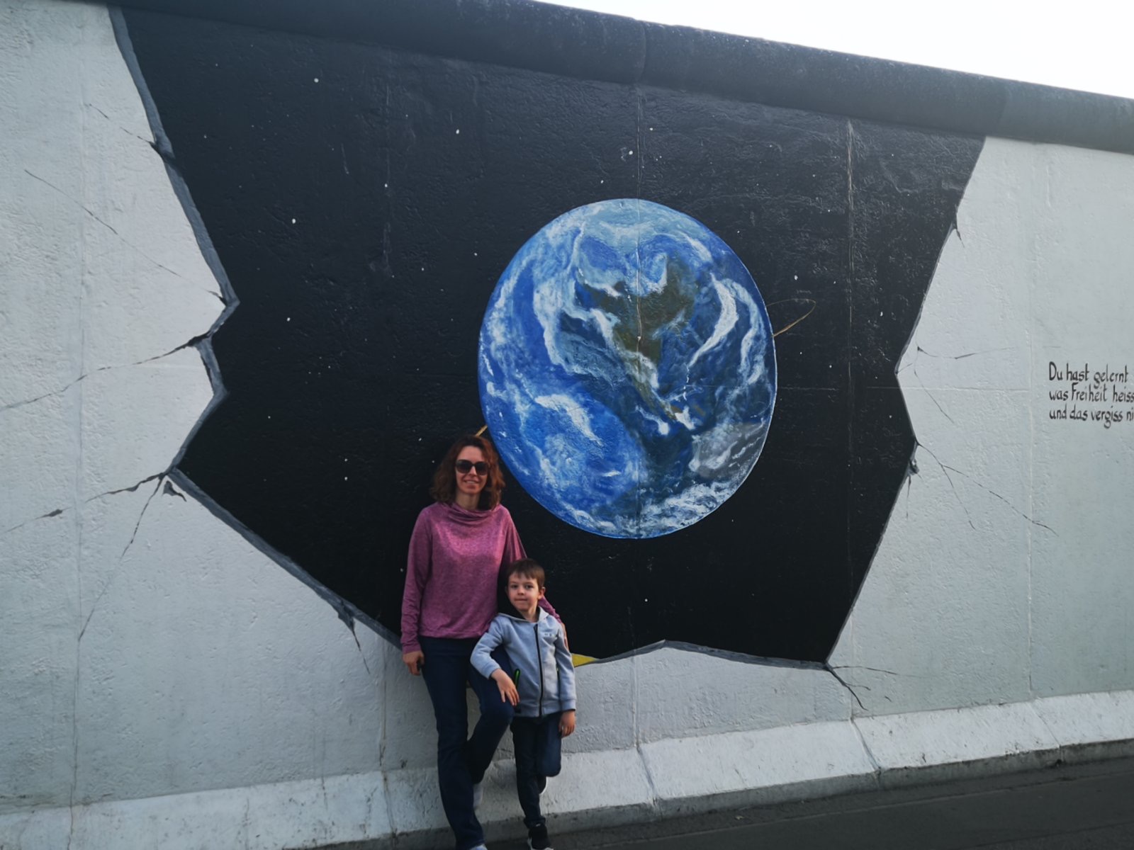 Nadja and son in front of street art.