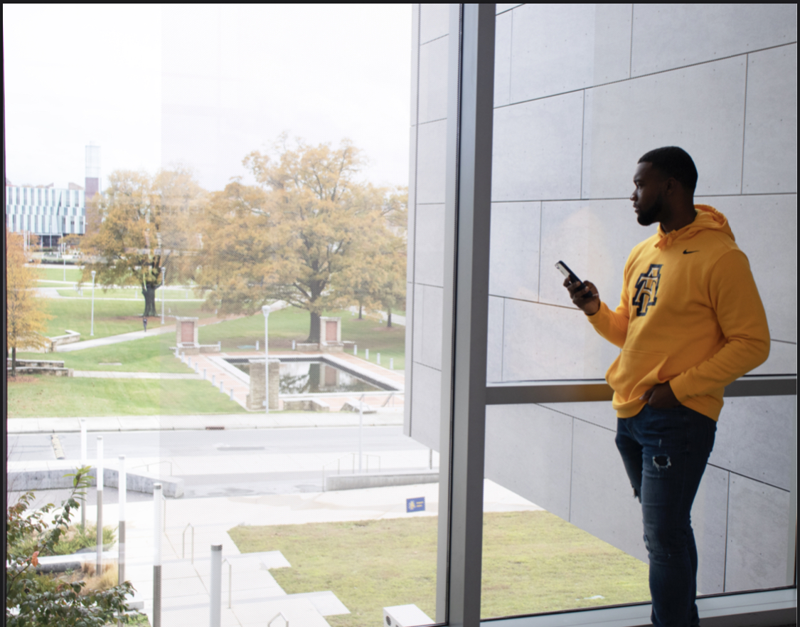 Michael holds his phone and looks out the window.