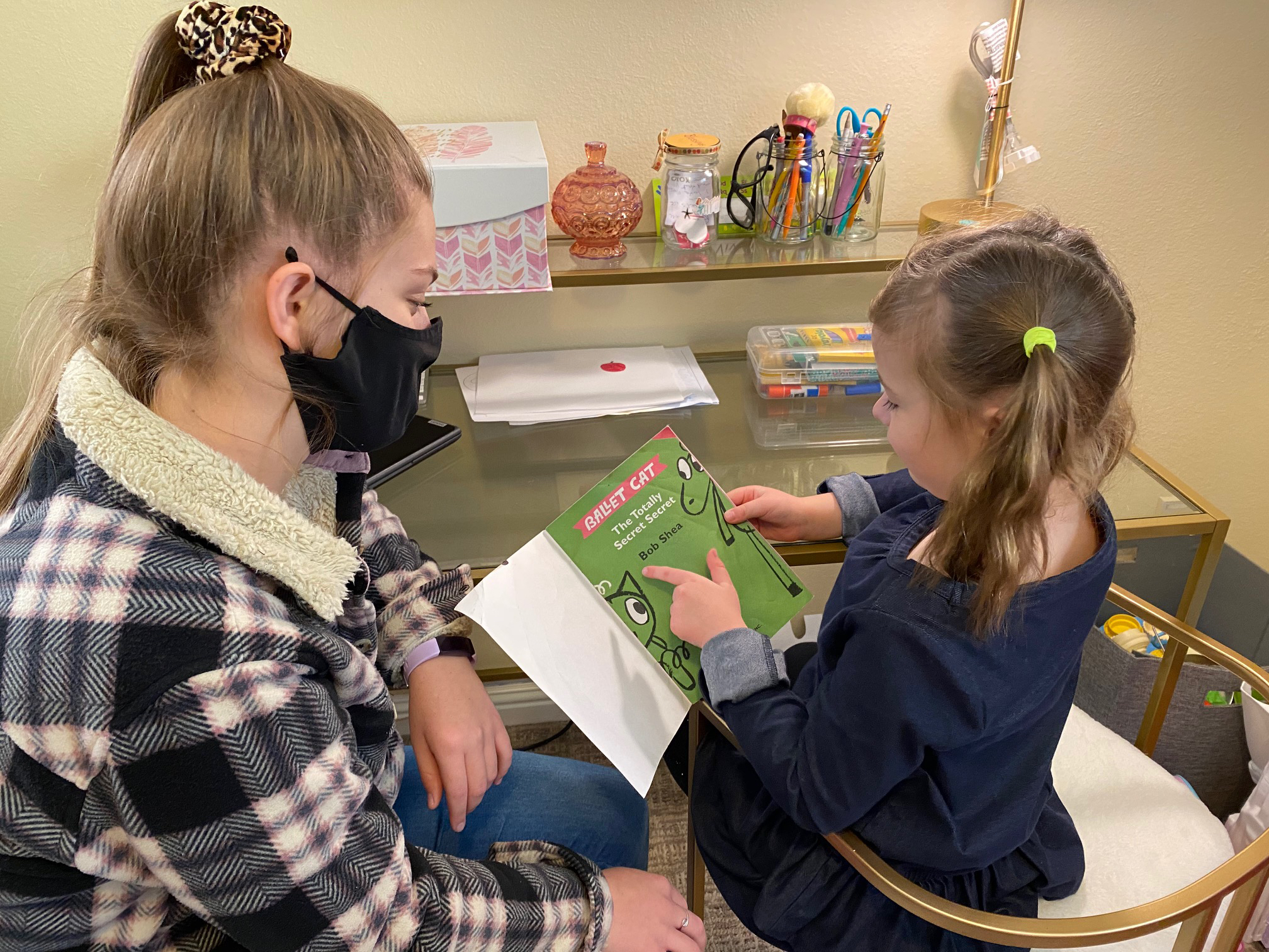 A child and adult read a book.