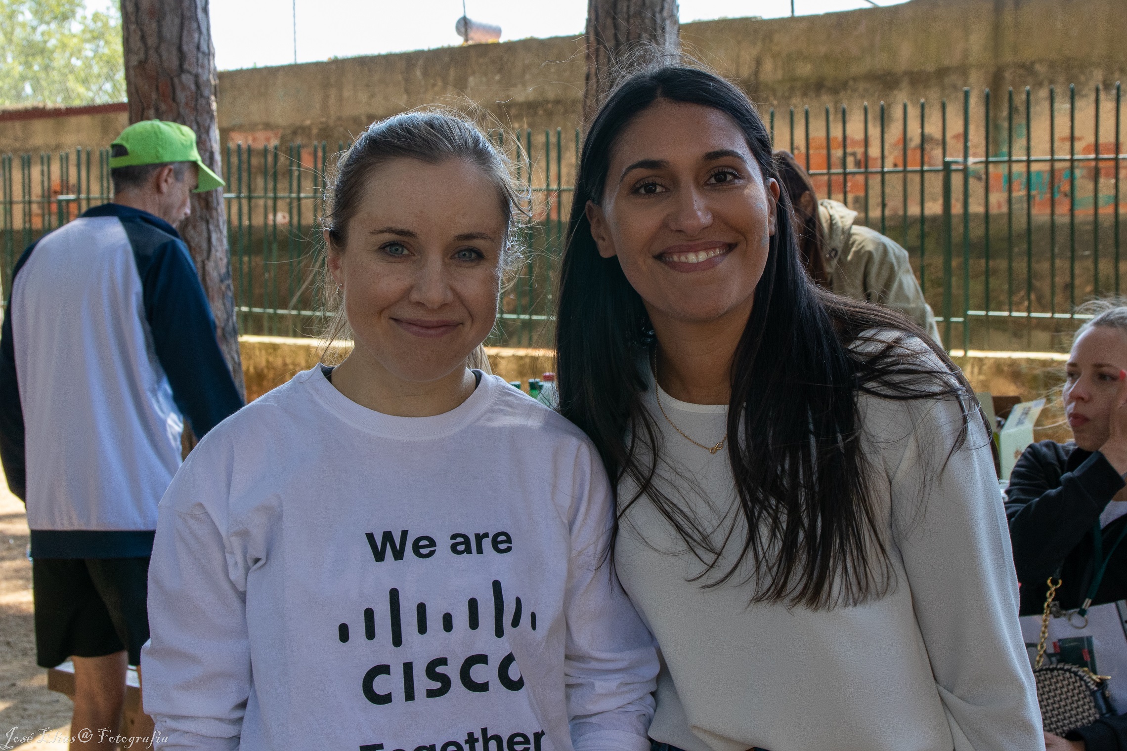 Two women smile at camera during volunteer event.