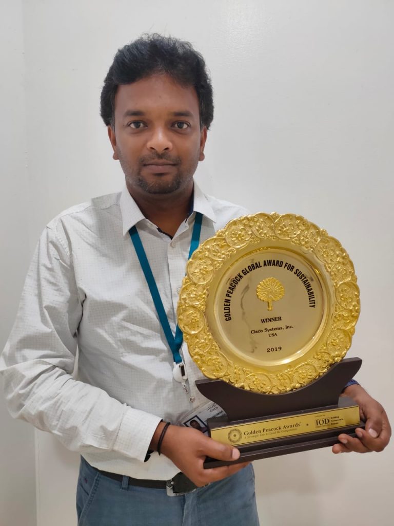 Vijay holding an award for sustainability