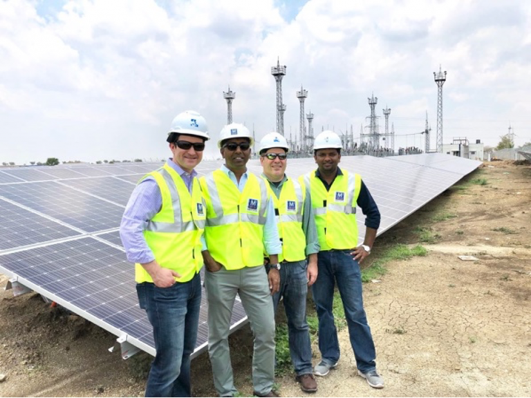 Cisco environmental sustainability employees in front of a solar panel