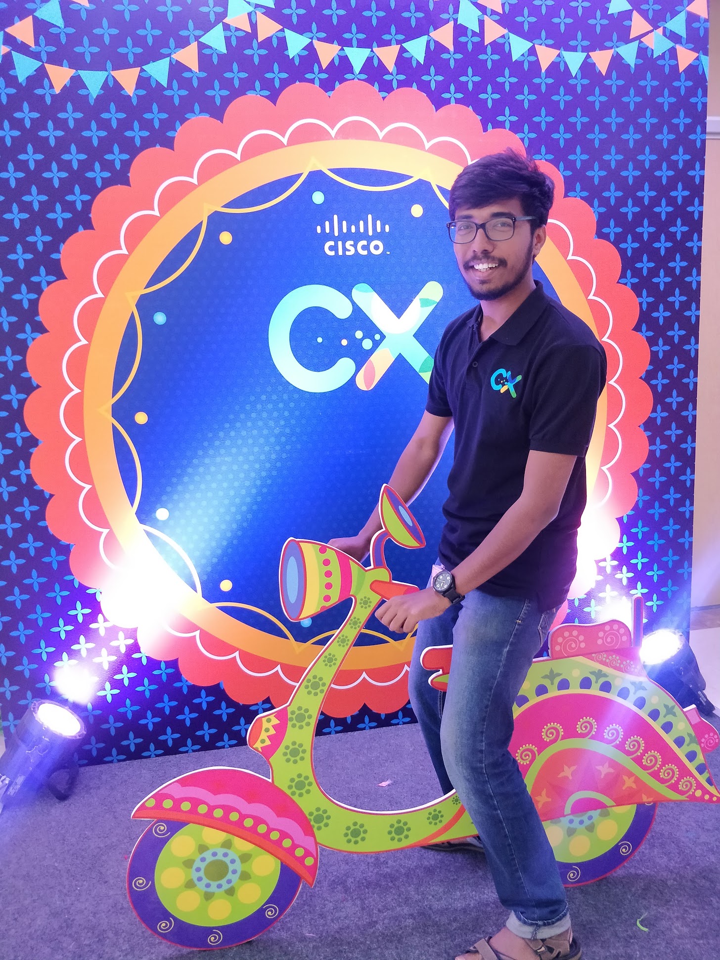 Vivek in front of a CX poster.