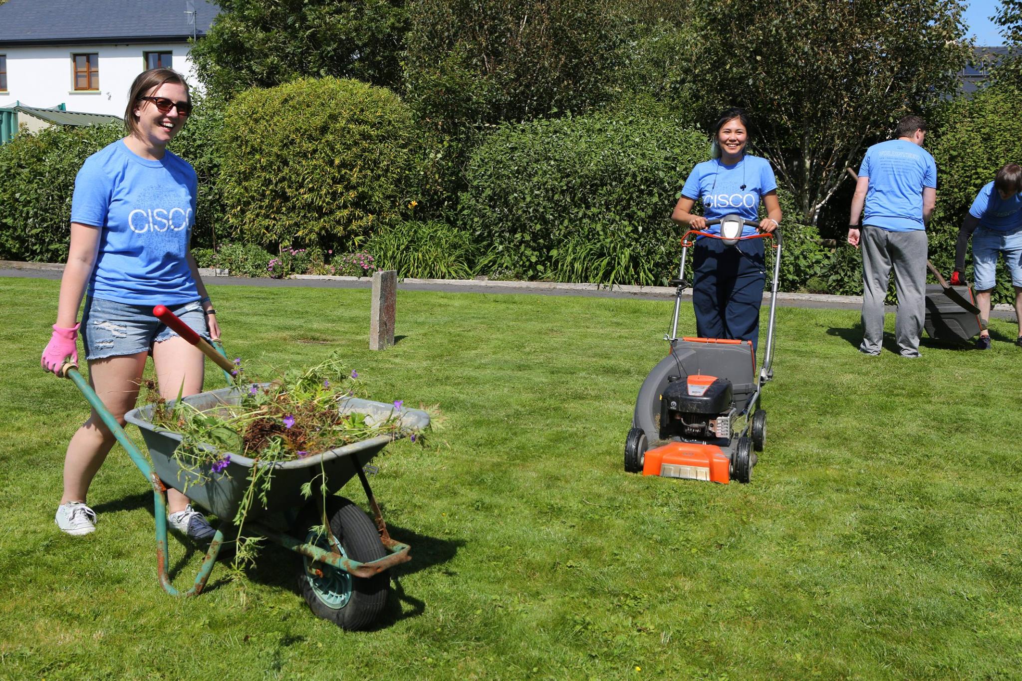 Sara at a giveback event doing yardwork alongside fellow coworkers. 