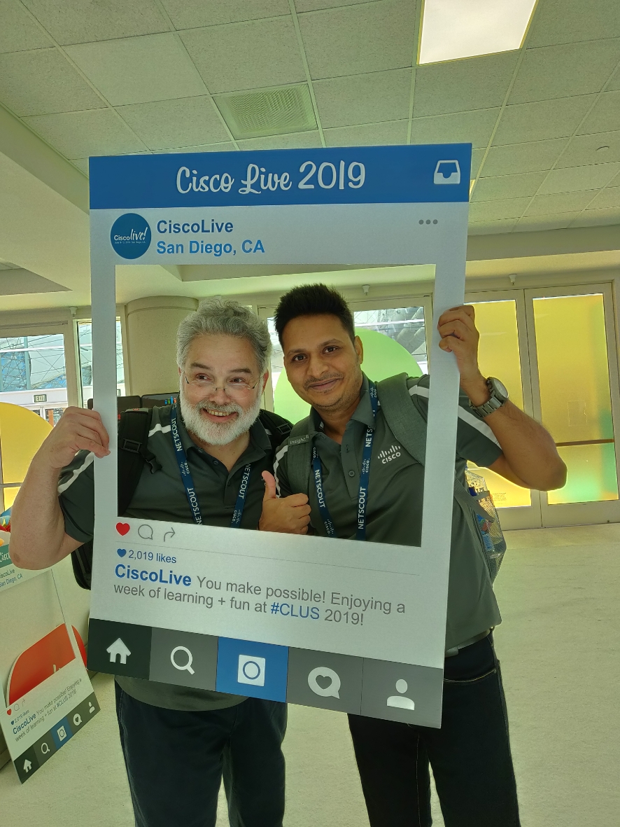 Rohit and colleague pose for a photo in an Instagram photo cutout during Cisco Live.