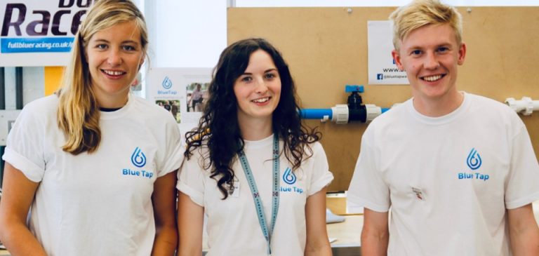 Three young people wearing matching shirts