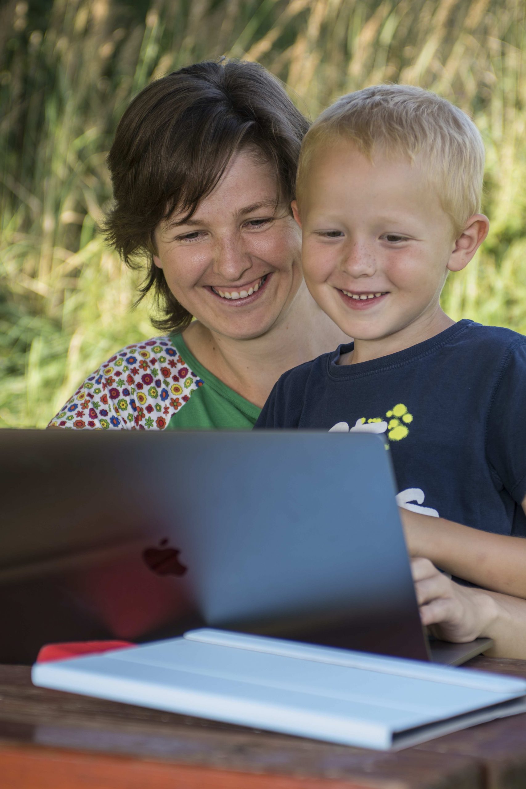 Adela working on the computer with her son. 