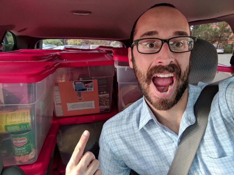 A young man in his car with food donations