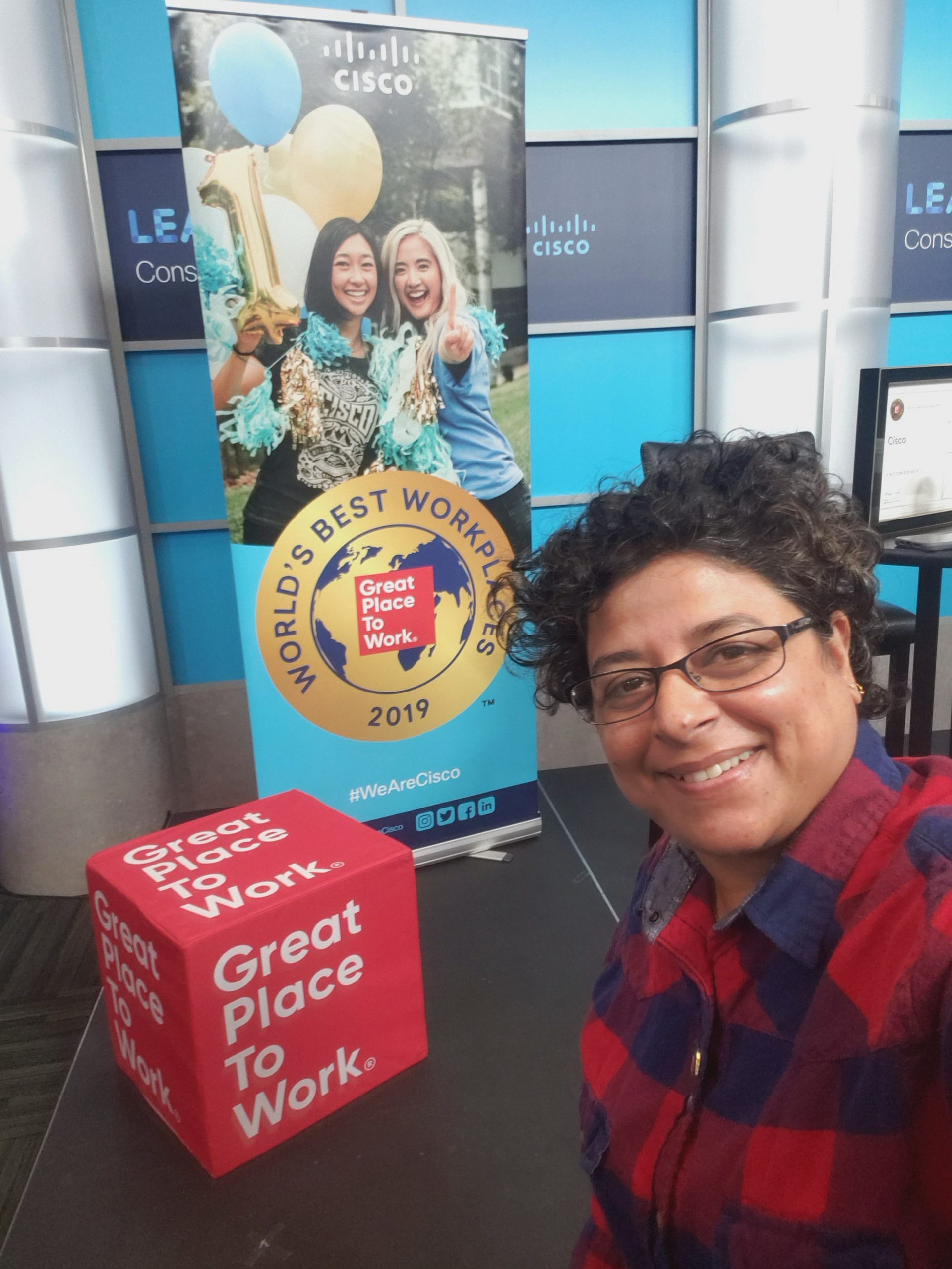 Rashmi next to the Great Place to Work Sign