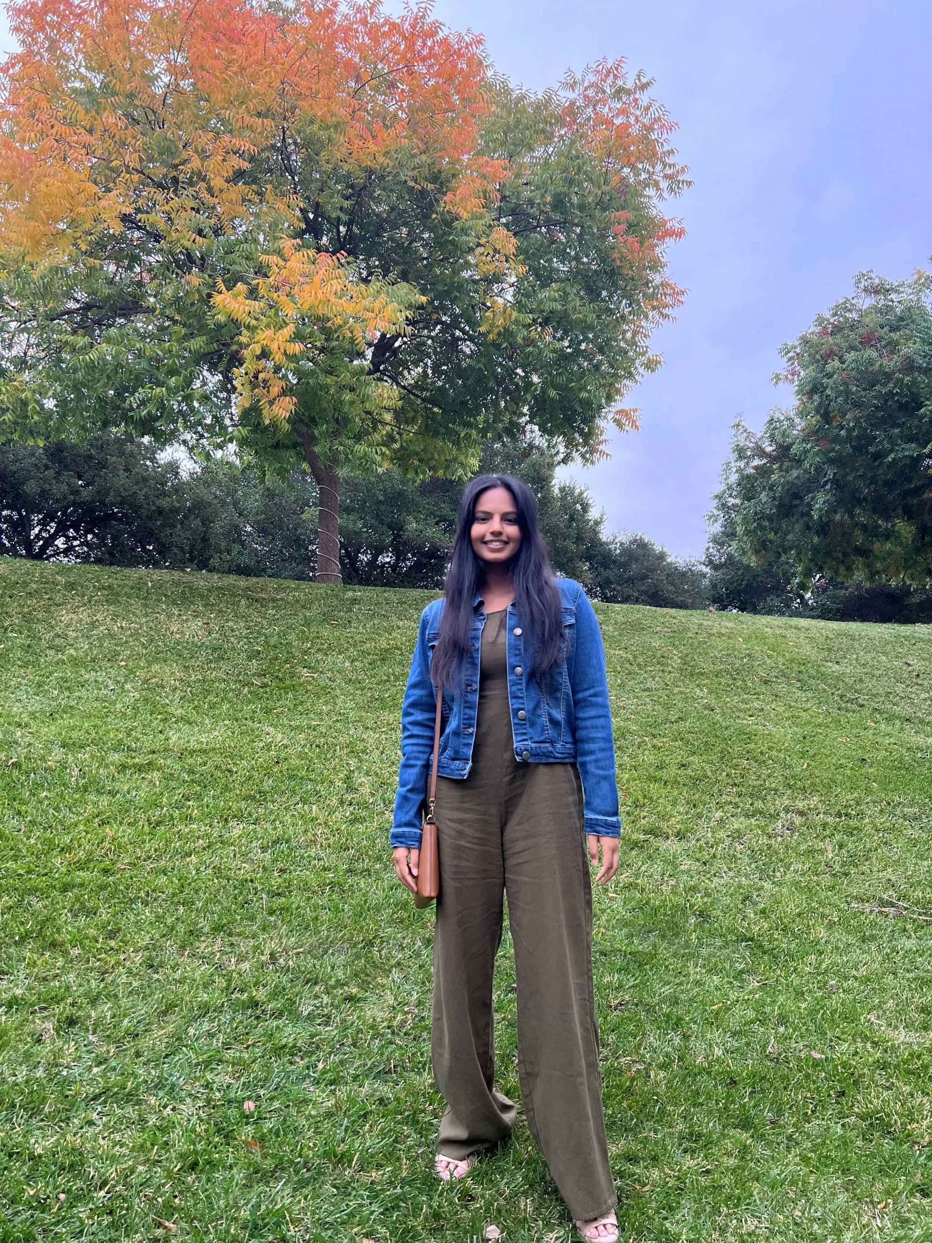Aishwarya standing on a grassy hill.