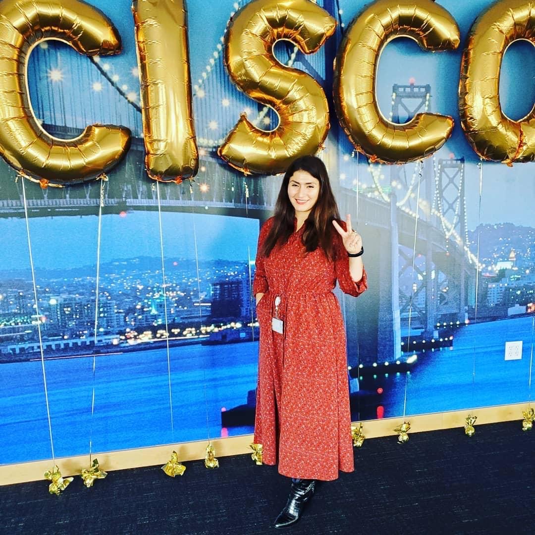 Pelin Salem stands in front of a Cisco balloon sign.