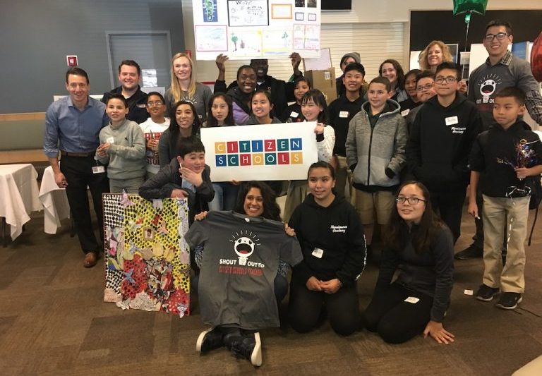 A group of children and adults holding up a Citizen Schools banner