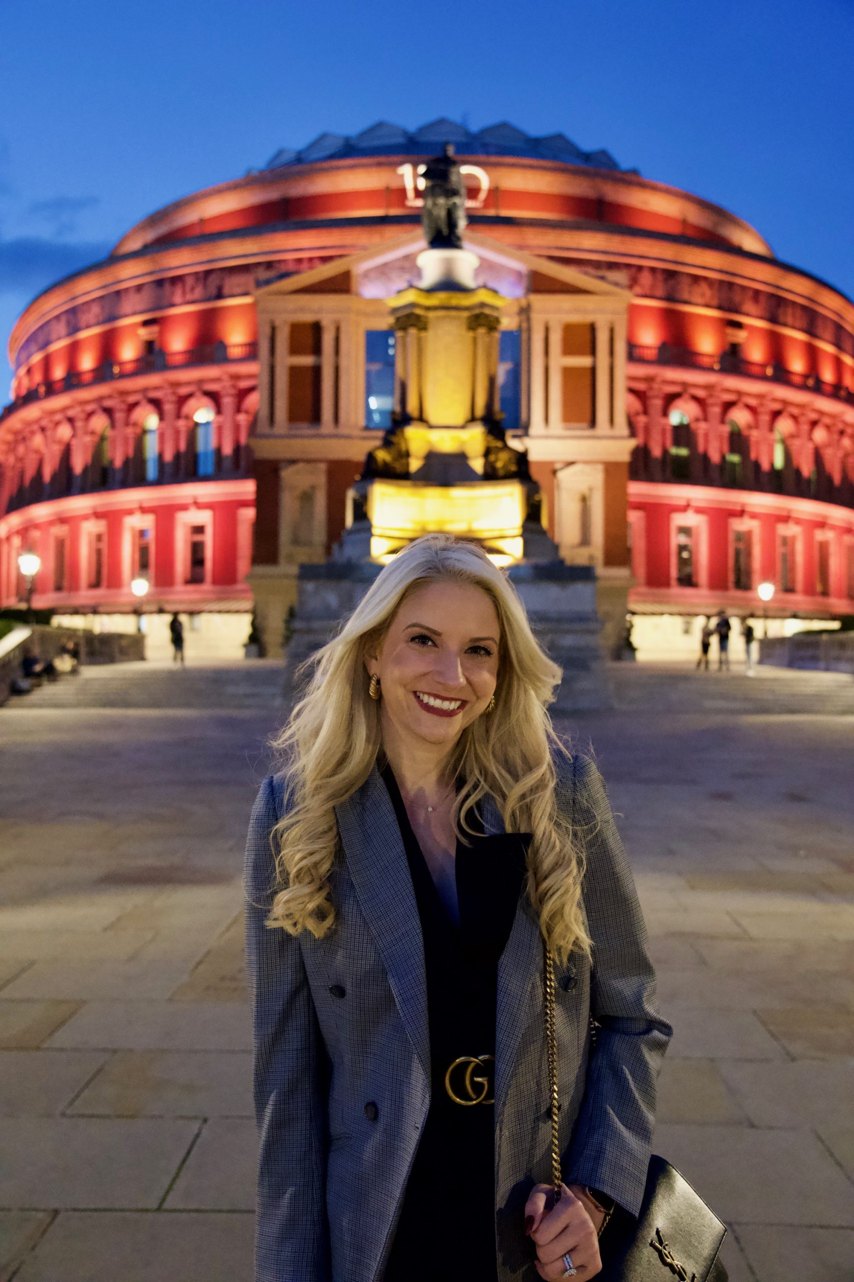 Madison stands outside with vibrant up lighting behind her.