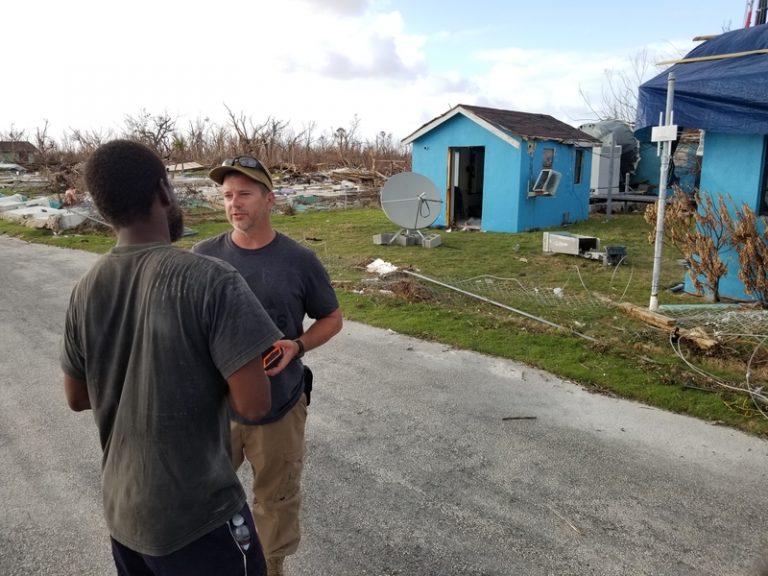 Two men discussing communication tech during a disaster.