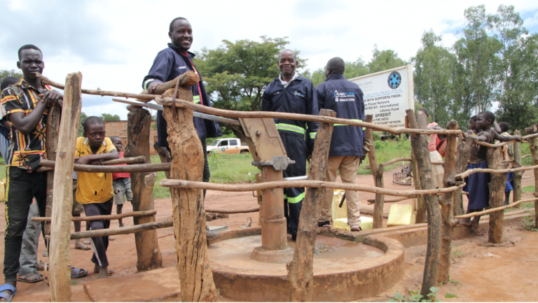 Maintenance technicians work to install an India Mark II on a village hand pump.