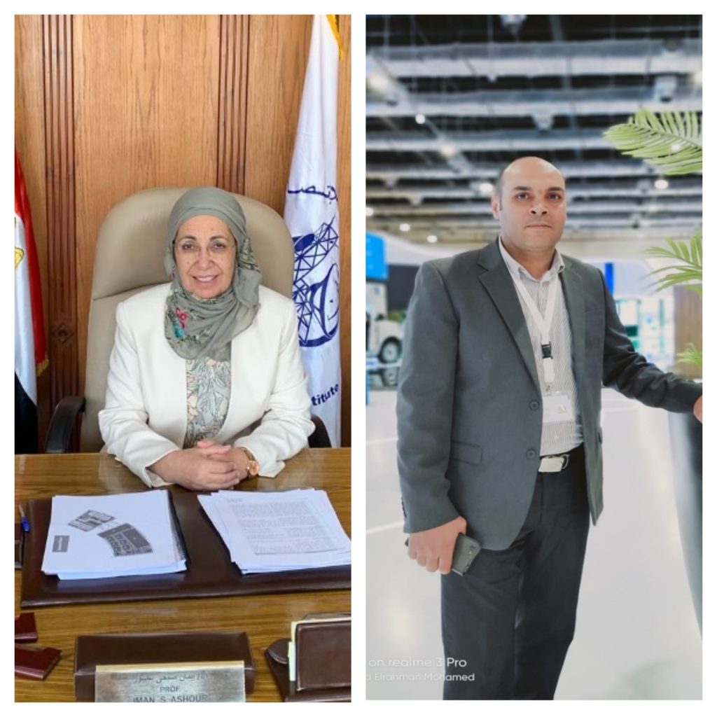 A woman sitting at a desk and a man standing