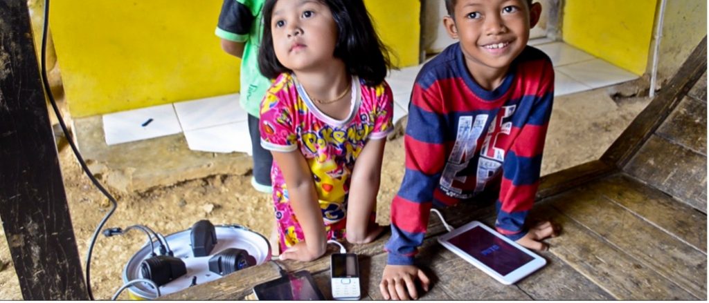 Kids using PowerWells system to charge their devices