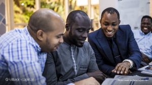 Three men sitting side by side, smiling