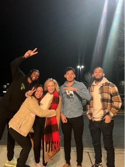 Cristopher and his friends from university huddled together smiling.