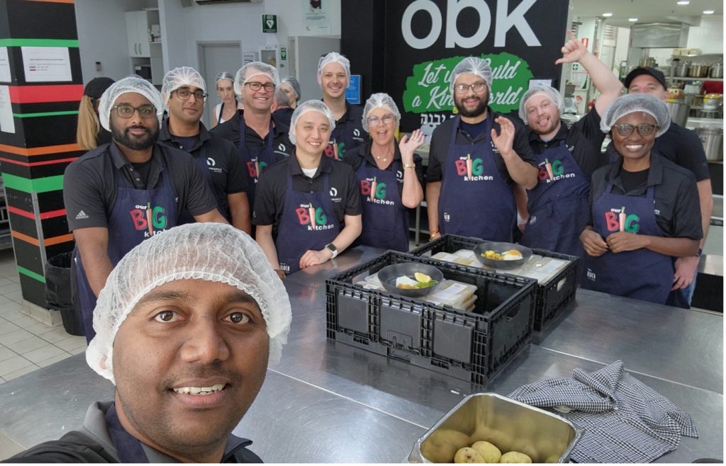 A group of people wearing hair nets in a kitchen setting