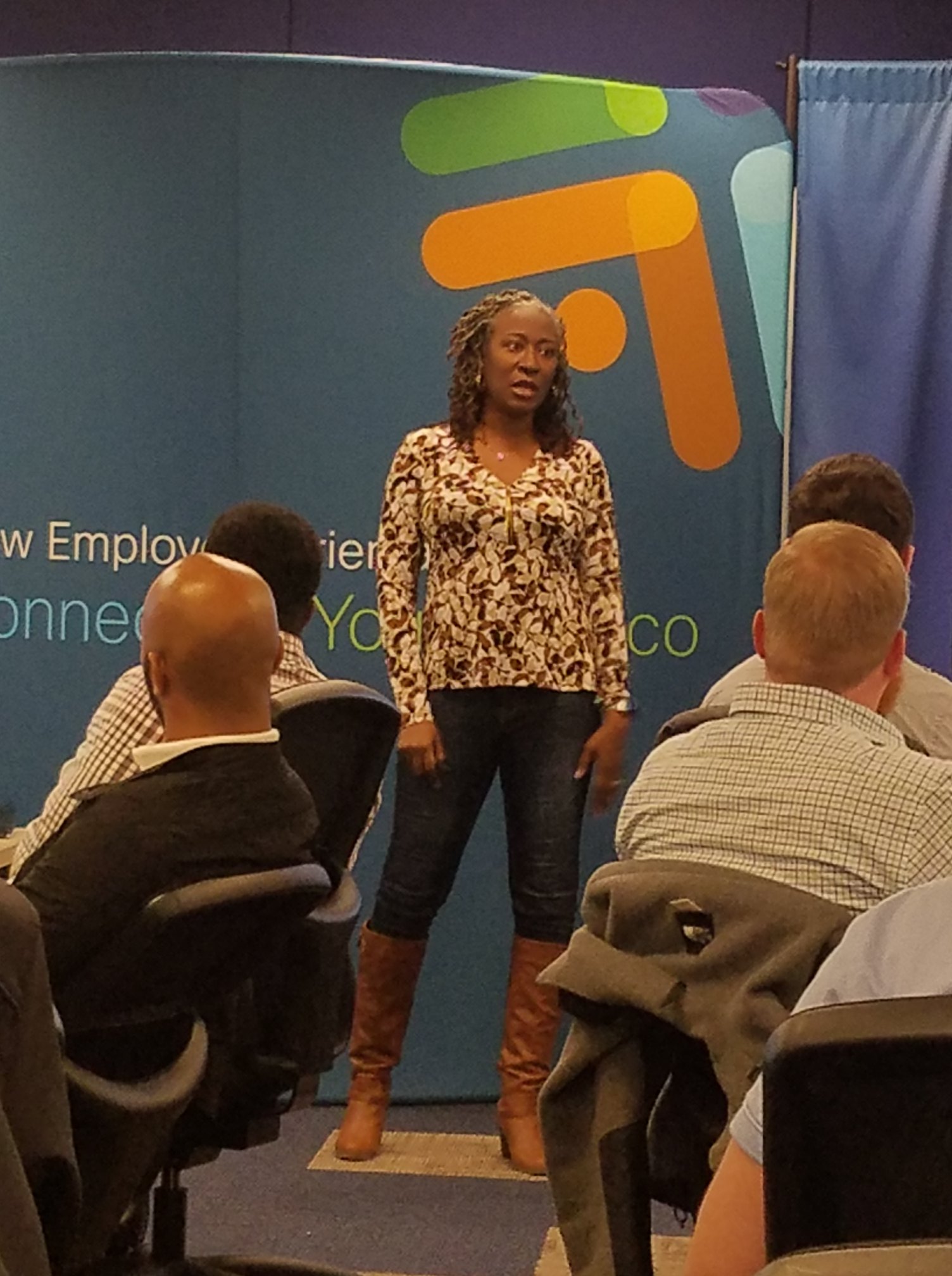 Karen McDonald stands and addresses a group of people.