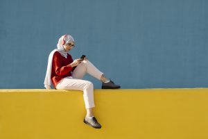 Woman looking at mobile phone on a wall