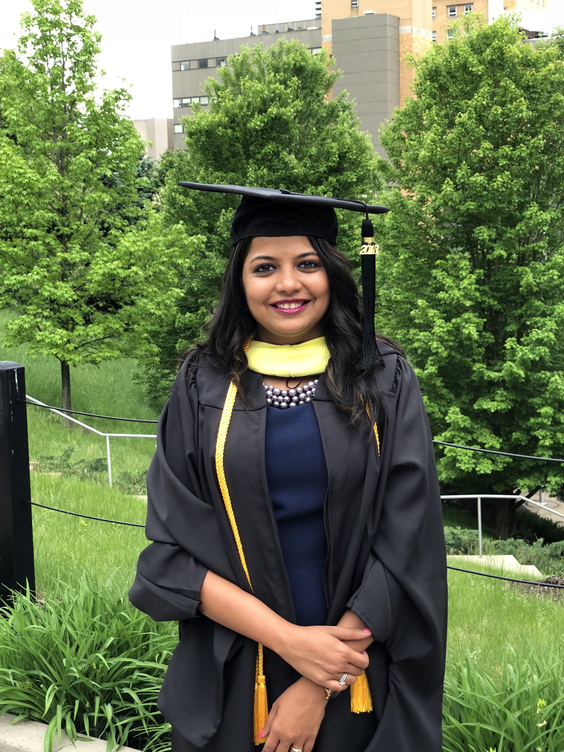 Pujita wearing a graduation cap and gown.